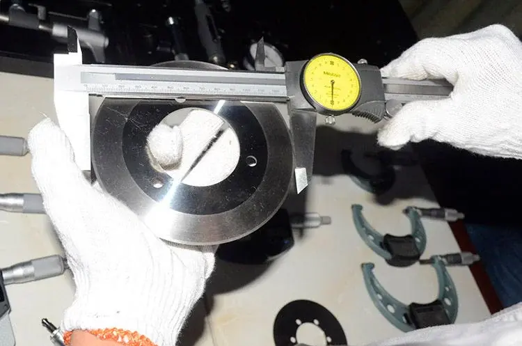 Inspector measuring a circular knife with a dial caliper